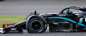 Lewis Hamilton steuert sein Fahrzeug mit einem platten Reifen über die Rennstrecke. 