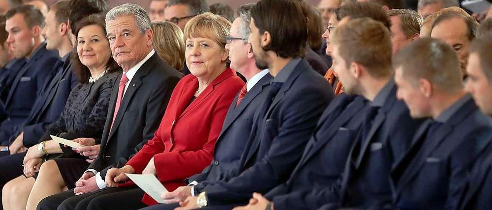 Die deutsche Nationalmannschaft wurde im Schloss Bellevue für den Titel bei der Fußball-Weltmeisterschaft 2014 in Brasilien mit dem Silbernen Lorbeerblatt geehrt. Mit dabei: Bundespräsident Joachim Gauck (l-r), Bundeskanzlerin Angela Merkel und Bundesinnenminister Thomas de Maizière. 