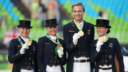 Da ist das Ding. Deutschlands Dressurreiter präsentieren stolz die Goldmedaillen. 