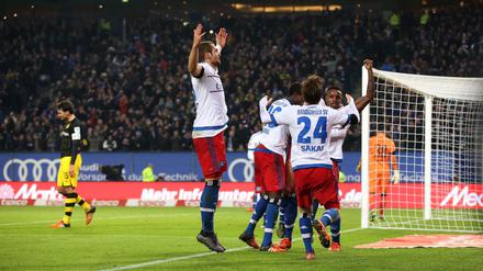 Hamburgs Spieler freuen sich über das Eigentor von Dortmunds Mats Hummels (l) zum 3-0. 