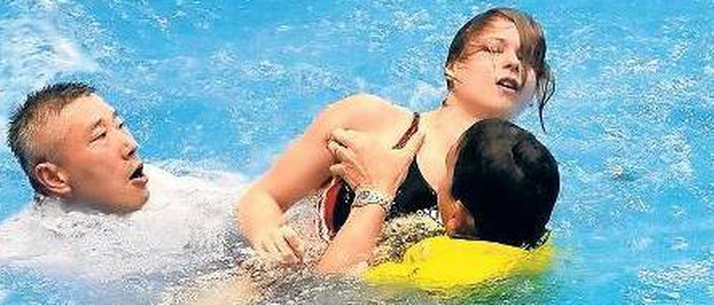Trainer retten die bewusstlose Maria Kurjo in Rostock aus dem Wasser.