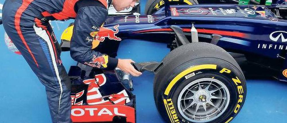 Hier eist der Chef noch selbst. Weil nach der Qualifikation kein Mechaniker das Auto anfassen darf, kühlte Sebastian Vettel die Bremsscheiben seines Autos selbst herunter. Foto: dpa
