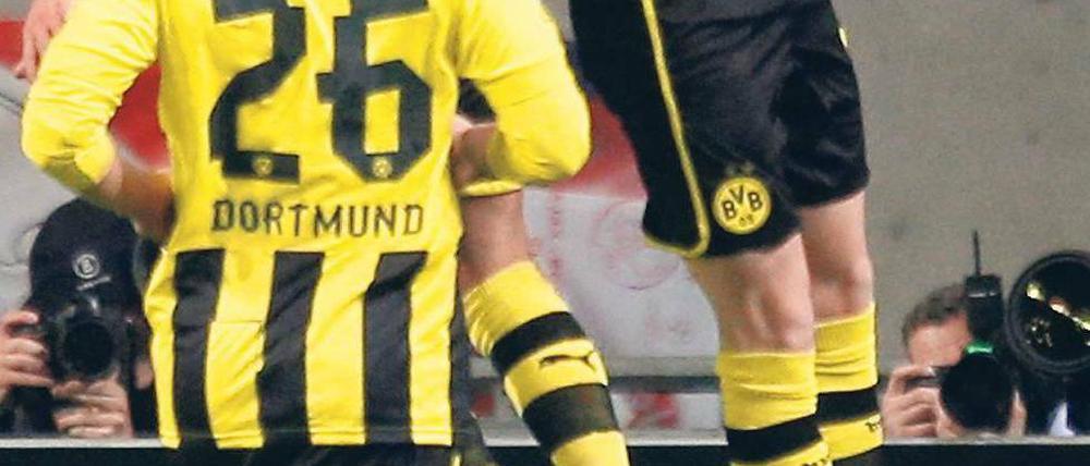 Und sie fliegen weiter. Dortmunds überragender Spieler Mario Götze feiert Marco Reus und dessen Tor zum 1:0, das der Partie schon früh die entscheidende Richtung gab. Foto: dapd