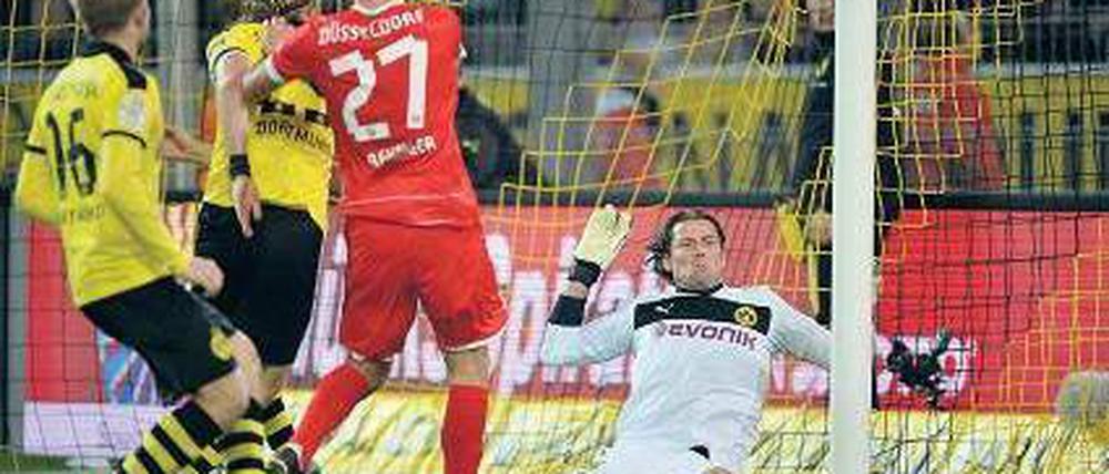 Wirkungstreffer. Stefan Reisinger (Mitte) überwindet Dortmunds Torwart Roman Weidenfeller und sichert den Düsseldorfern einen Punkt. Foto: dapd