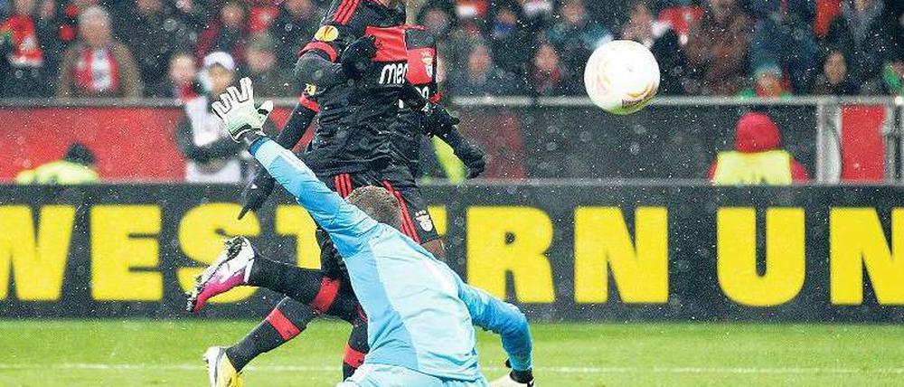 Entscheidung im Schneetreiben. Oscar Cardozo von Benfica Lissabon überwindet Leverkusens Torhüter Bernd Leno nach einer feinen Einzelleistung und schießt das einzige Tor des Spiel. Foto: dpa