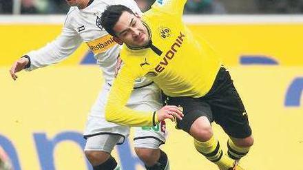 Dortmunder im leichten Fall. Ilkay Gündogan (vorn) und die Dortmunder hatten wenig Spaß mit Amin Younes (rechts), der den Ausgleich für die Mönchengladbacher erzielte. Foto: Reuters