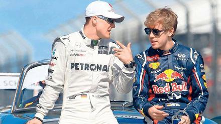 Rot ist deine Farbe! Michael Schumacher (l.) will Sebastian Vettel zu Ferrari lotsen. Foto: dpa