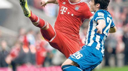 In Bedrängnis gebracht. Herthas Mittelfeldspieler Nico Schulz verhindert, dass Bayern-Stürmer Mario Mandzukic den Ball in Ruhe annehmen kann. Am Tag nach dem 2:3 pendelten die Gefühle der Hertha-Spieler zwischen Stolz und Trauer. Foto: AFP