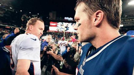 Hand drauf. Tom Brady (r.) von den New England Patriots trifft am Sonntag zum vierten Mal in den Play-offs auf seinen Quarterback-Rivalen Peyton Manning, der im zweiten Jahr für die Denver Broncos spielt. Zweimal konnte sich bisher Tom Brady durchsetzen. 