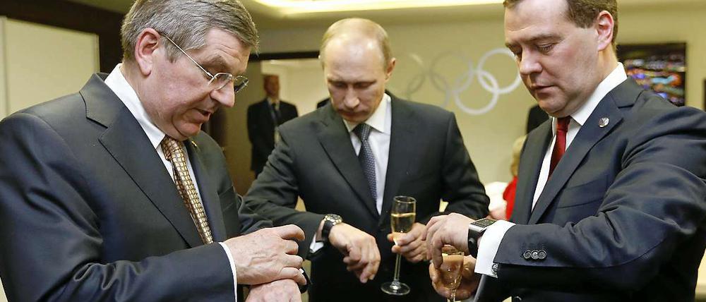 Uhrenvergleich. IOC-Präsident Thomas Bach mit Wladimir Putin und Dmitry Medvedev (von links).