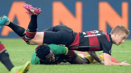 Ein Fall für zwei. Nationalspieler Marco Reus landet nach einem Zweikampf auf Kameruns Nicolas Nkoulou.