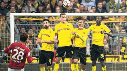 Die Borussia bröckelt. Hannovers Hiroshi Kiyotake zirkelt den Ball zum 1:0 über die Mauer des BVB. Ilkay Gündogan, Sven Bender, Pierre-Emerick Aubameyang und Adrian Ramos (von links nach rechts) springen vergeblich in die Luft.