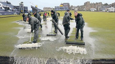 Läuft doch. Nach heftigen Regenfällen am zweiten Turniertag in Schottland entfernen Groundkeeper das Wasser vom Old Course in St. Andrews.