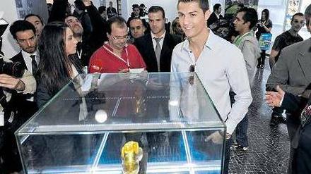 Schuhtick. Cristiano Ronaldo stellt sich während der Museumseröffnung 2013 neben einen seiner zwei Goldenen Schuhe, die er als weltbester Torschütze bekommen hat.