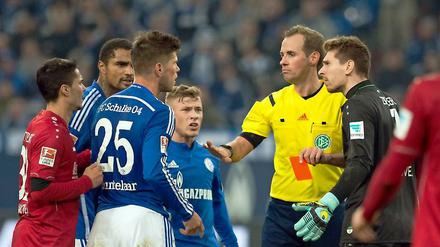 Im Spiel gegen Hannover. Schiedsrichter Sascha Stegemann (2.v.r) zeigt Schalkes Klaas-Jan Huntelaar (3.v.l.) die Rote Karte.