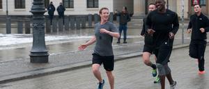 Poser oder Poster? Facebook-Gründer Mark Zuckerberg (l.) joggt in Berlin mit Bodyguards über den Pariser Platz.