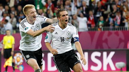 Philipp Lahm (r.) und Marco Reus jubeln gemeinsam im Trikot der deutschen Nationalmannschaft.