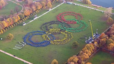 Wir wollen die Spiele. Mehrere Hundert Menschen bilden mit verschieden farbigen Ponchos am 08.11.2015 im Stadtpark in Hamburg die Olympischen Ringe. 