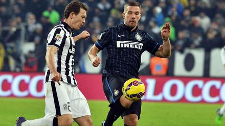 Lukas Podolski (r.) bei seinem Debüt für Inter Mailand gegen Stephan Lichtsteiner von Juventus Turin.