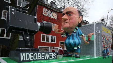 Ein Motivwagen mit dem Motto "Videobeweis" und einem Abbild von Sepp Blatter steht am Rosenmontag in Köln im Regen.