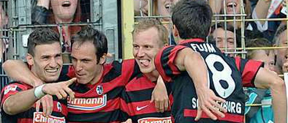 Die Freiburger Spieler feiern ihren Siegtorschützen Daniel Caligiuri (l.).
