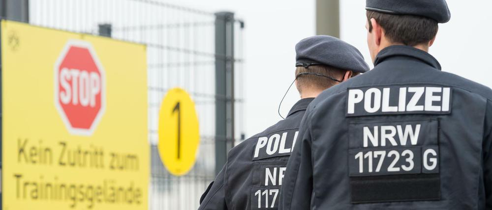 Polizeibeamte stehen vor der Zufahrt zum Trainingsgelände von Borussia Dortmund. 