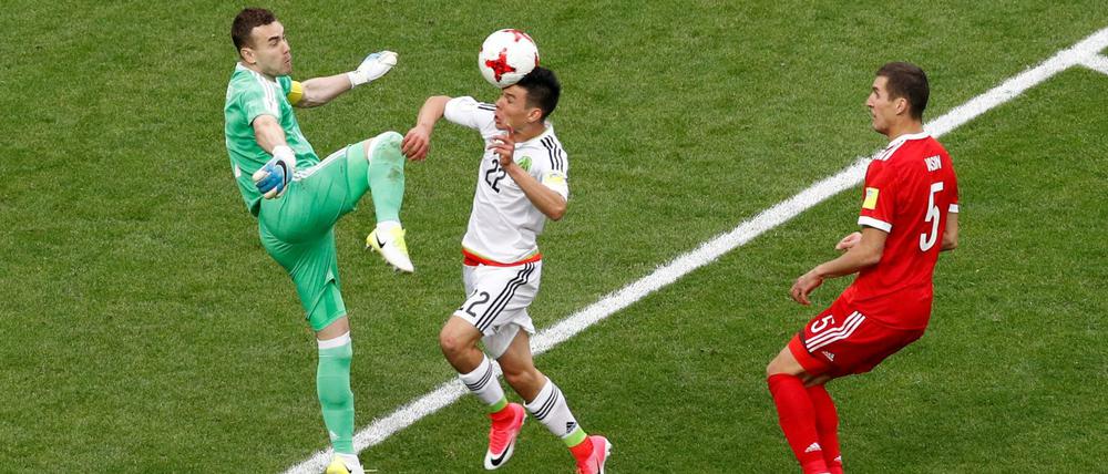 Russlands Torhüter Igor Akinfejew verpasst vor dem Mexikaner Hirving Lozano im entscheidenden Moment den Ball.