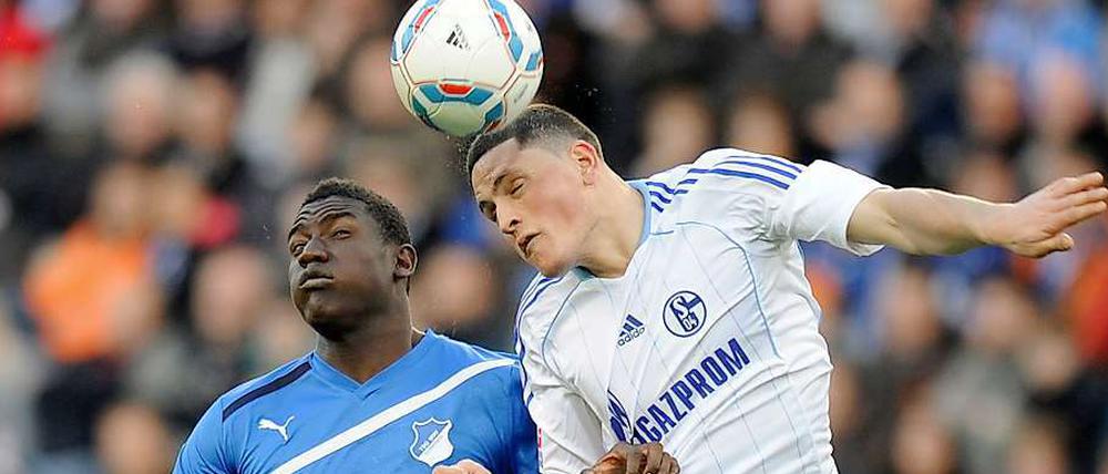 Hoffenheims Peniel Mlapah (l.) und der Schalker Kyriakos Papadopoulos kaempfen um den Ball.