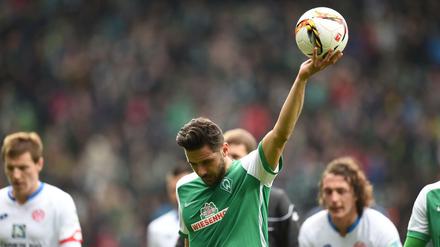 Werders Rekordtorschütze Claudio Pizarro hält den Ball, den er per Elfmeter zum 1:1 und damit zum 101. Tor für Werder geschossen hat, hoch.