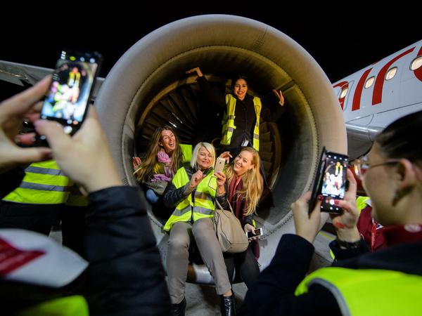 Crewmitglieder der Air Berlin lassen sich auf dem Flughafen in München in der Turbine der Maschine von Air Berlin fotografieren, mit der der letzte Flug der Airline durchgeführt wird.