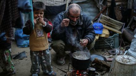 Der 51-jährige Palästinenser Jamal Shobaki (r) kocht in Khan Younis (Palästinen. Autonomiegebiete) im südlichen Gaza-Streifen in einem Topf Hähnchenfleisch für seine Kinder. Mehr als zwei drittel der Bewohner des vom Israel kontrollierten Gaza-Streifens sind auf die Unterstützung der UN-Hilfsorganisationen angewiesen. 