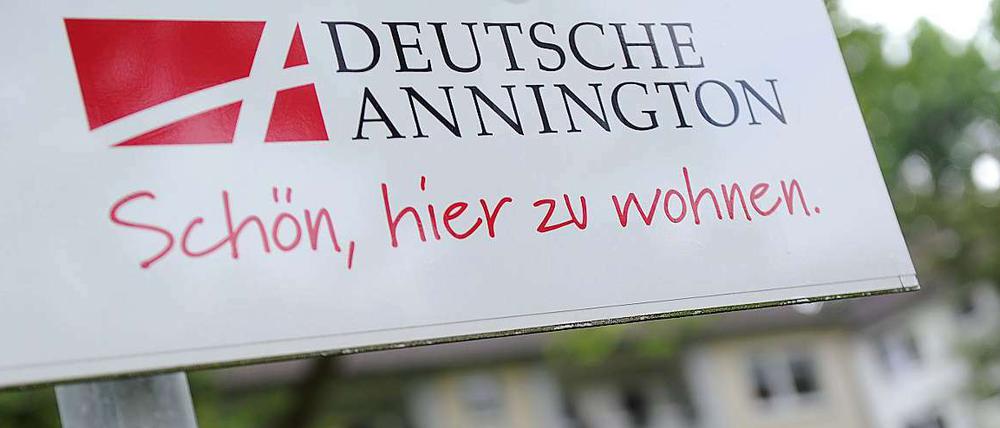 Ein Firmenschild der Deutschen Annington vor einem Mietshaus.