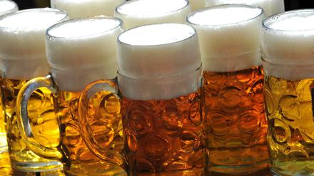 Maßkrüge stehen auf der Schänke in einem Biergarten auf dem Oktoberfest in München.