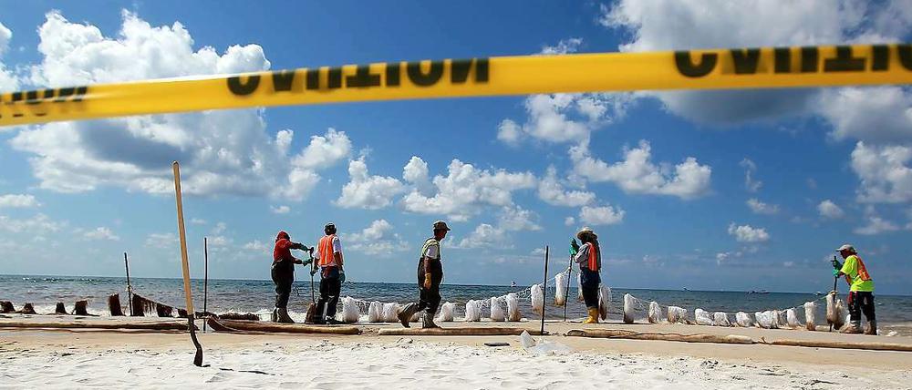 In Orange Beach, Alabama, befestigen Arbeiter Barrieren, die das Öl aufsaugen sollen, wenn es an der Küste angeschwemmt wird.