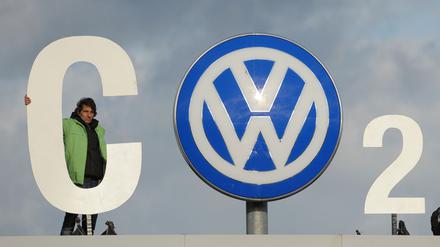 Greenpeace-Aktivisten stehen mit einem CO2 Banner über dem Werkstor von Volkswagen in Wolfsburg.