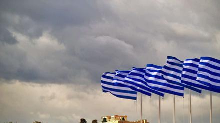Griechische Fahnen wehen in Athen am Panathinaiko-Stadion vor der Akropolis