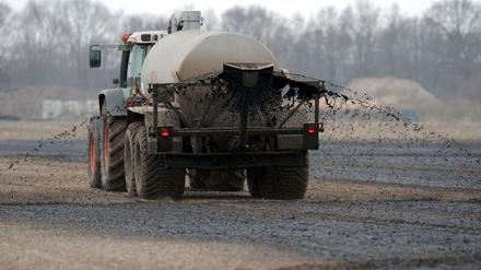 Mit einem Traktor wird hier auf einem Feld bei Jacobidrebber (Niedersachsen) Gülle ausgebracht. Die Überdüngung ist Ursache hoher Nitratwerte im Trinkwasser.