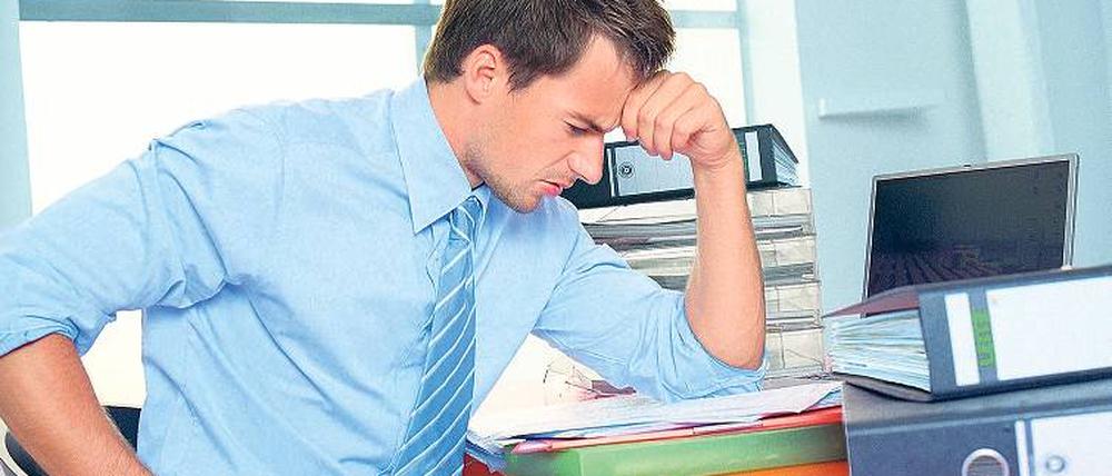 Schreibtischtäter. Viele sitzen krumm, zu niedrig und angespannt bei der Arbeit. Verspannungen und Rückenprobleme sind die Folge – wenn man nichts unternimmt. Foto: dpa
