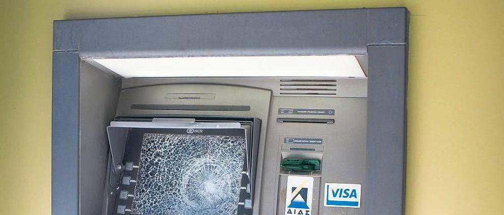 Zerschlagen. So lautet die wütende Losung über einem Geldautomaten in der nordgriechischen Stadt Thessaloniki – aber das sieht man auch so.