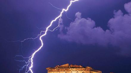 Stürmische Zeiten. Ein Blitz nahe der Athener Akropolis. Die griechische Regierung muss immer neue Rückschläge im Kampf gegen die Pleite offenbaren.