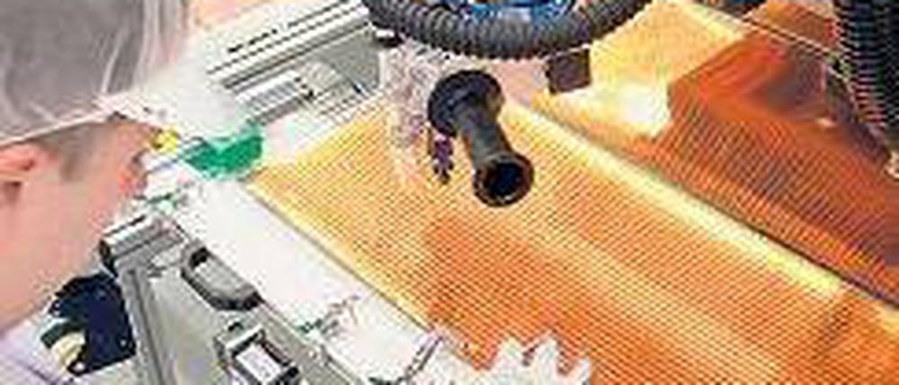 Es ist nicht alles Gold, was glänzt. Ein Techniker von Odersun verlötet in Fürstenwalde Solarmodule. Foto: p-a/dpa