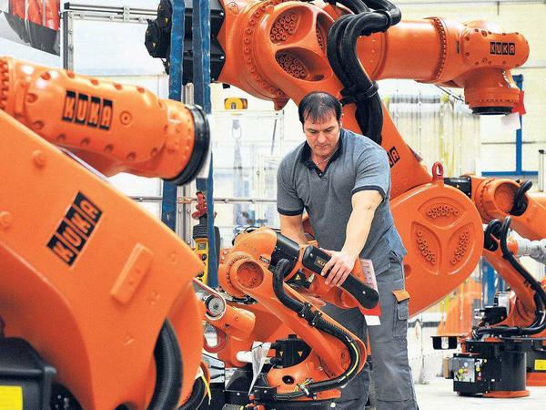 Hand in Hand. In den modernsten Werken von Daimler arbeiten Mitarbeiter eng mit Kuka-Robotern zusammen. 