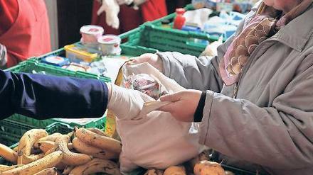 Eine Mitarbeiterin der Berliner Tafel versorgt Bedürftige mit Obst und Gemüse. 