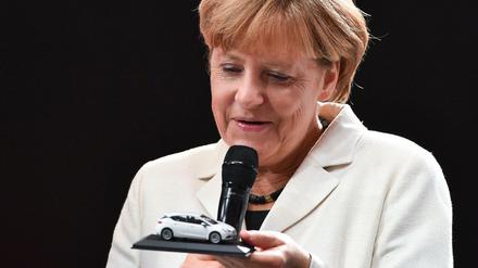 Angela Merkel hält bei der Eröffnung der Internationalen Automobilausstellung IAA in Frankfurt am Main ein Miniaturmodell des neuen Opel Astra in den Händen.