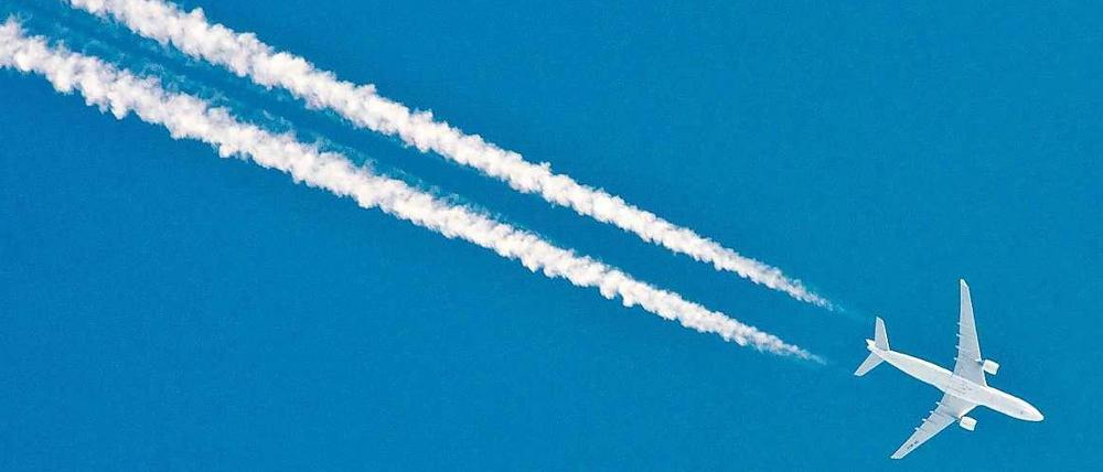 Ein Flugzeug hinterlässt am Himmel eine weiße Spur
