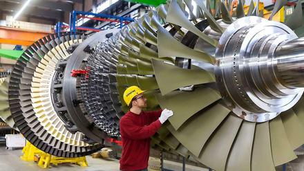 Ein Arbeiter kontrolliert eine Turbine, die bei Siemens in Berlin für ein Düsseldorfer Kraftwerk gefertigt wird. 