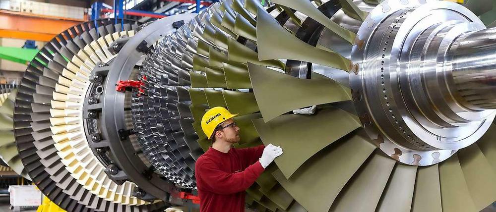 Ein Arbeiter kontrolliert eine Turbine, die bei Siemens in Berlin für ein Düsseldorfer Kraftwerk gefertigt wird. 