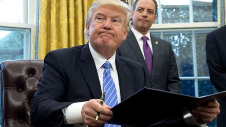 Ob er sich das gut überlegt hat? Donald Trump setzt seine Unterschrift unter das Dekret, mit dem die USA aus den TPP-Verhandlungen aussteigen.