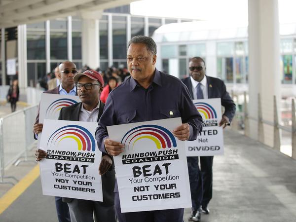 Reverend Jesse Jackson (Mitte) protestiert am O'Hare International Airport in Chicago gegen United. 