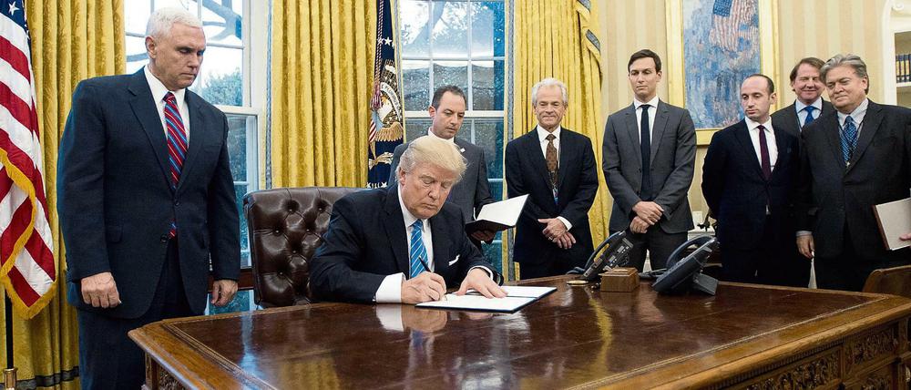 Der weißhaarige ältere Herr rechts neben Trump ist dessen Wirtschaftsberater Peter Navarro.